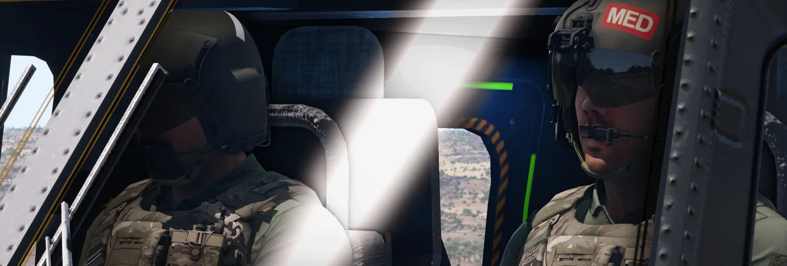 Aircrew and a medic seated inside a helicopter in flight.