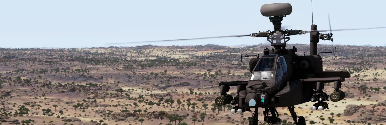 An Apache attack helicopter banking over open terrain.