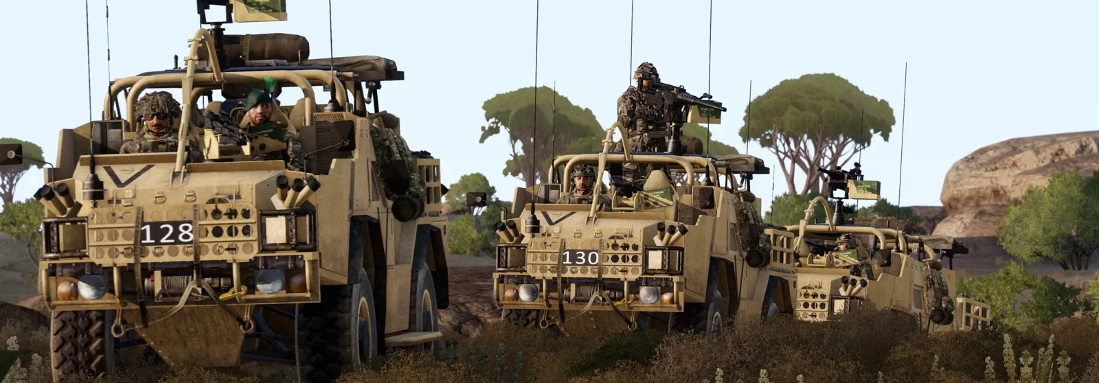 A convoy of Foxhound protected patrol vehicles moving through open terrain, gunners manned up.