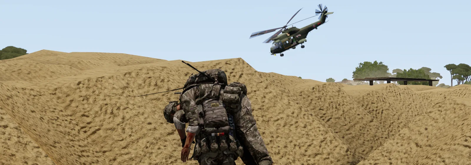 A medic carrying a casualty as a helicopter comes in to extract.