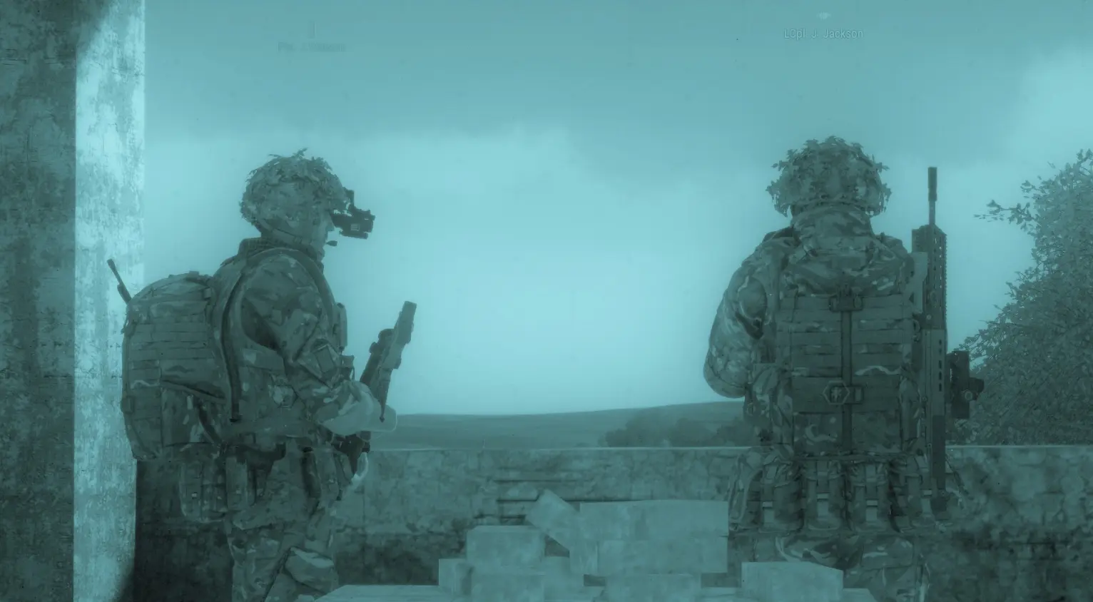 Two soldiers on nightvision lookout from a sandbagged position, name tags visible