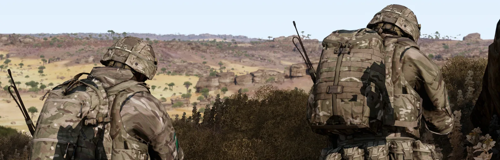 Two soldiers on overwatch above open terrain.