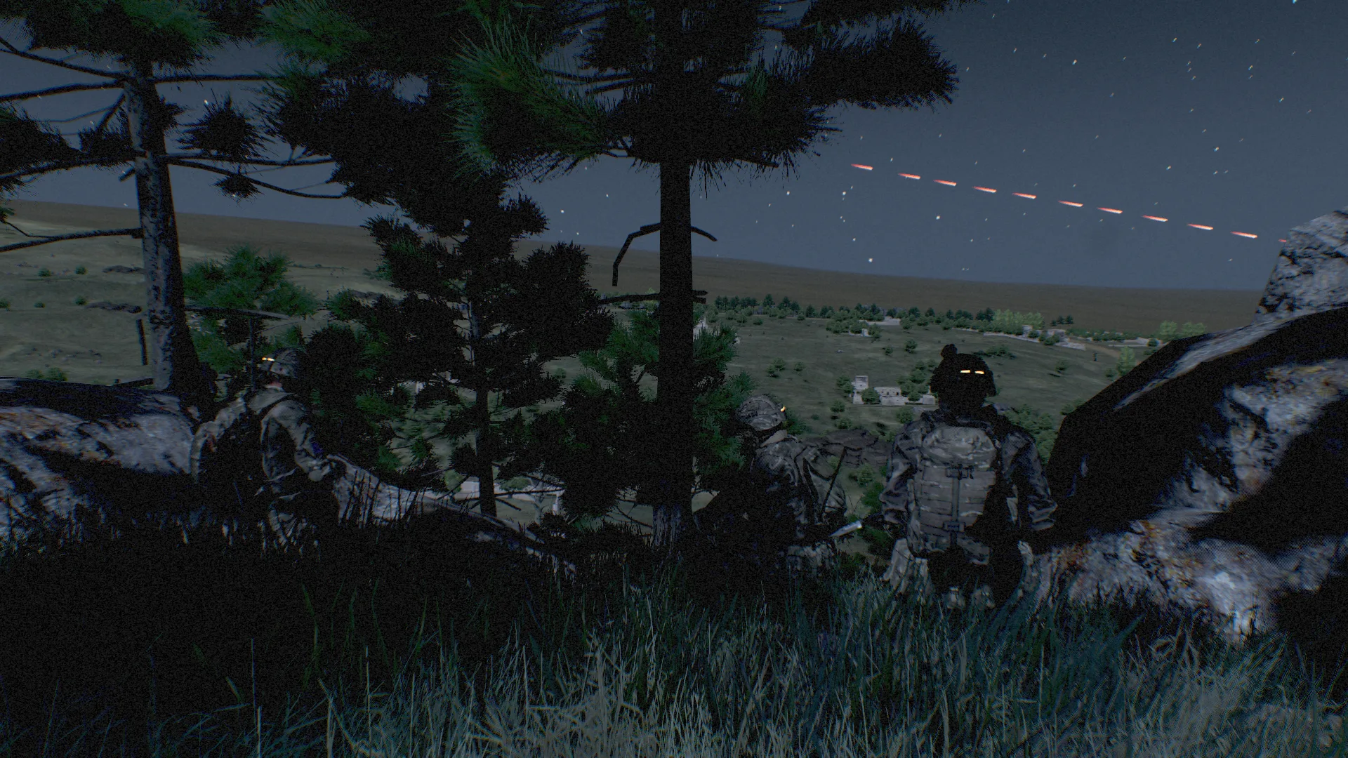 Night overwatch position among trees and rocks, with a tracer arcing over a valley and village below.